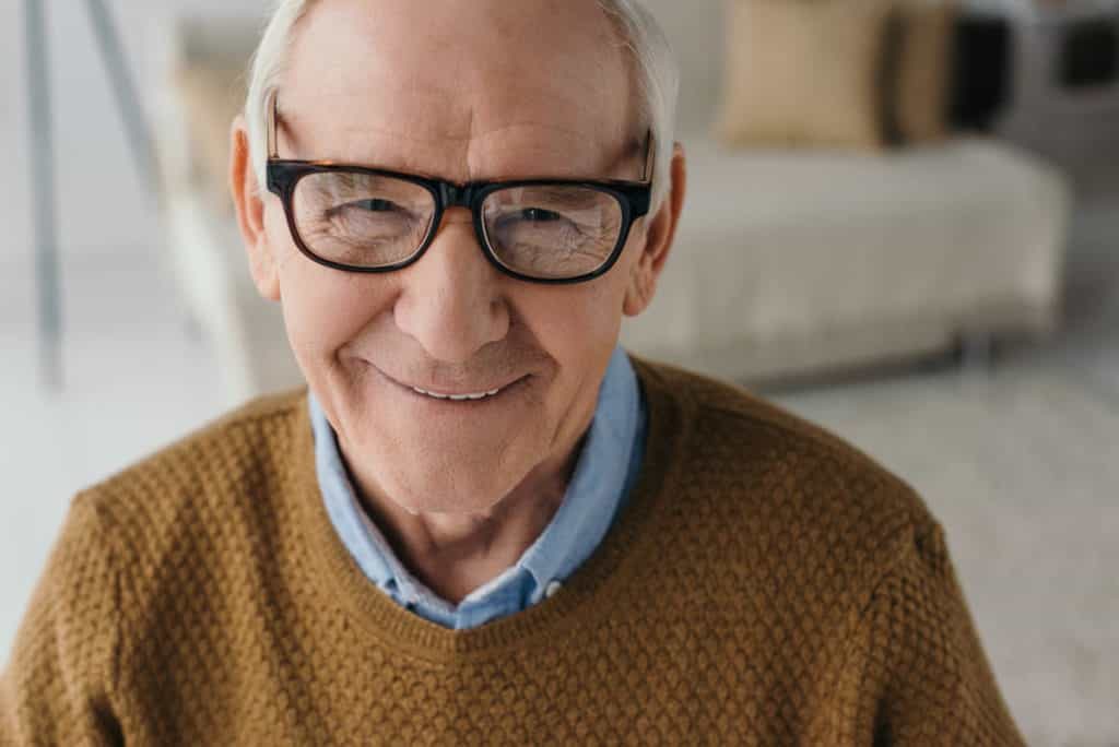 elderly man with glasses smiling