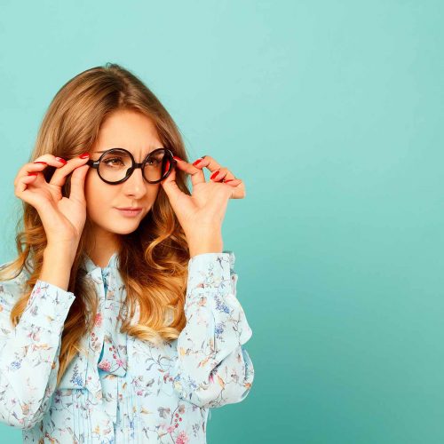 woman putting on glasses